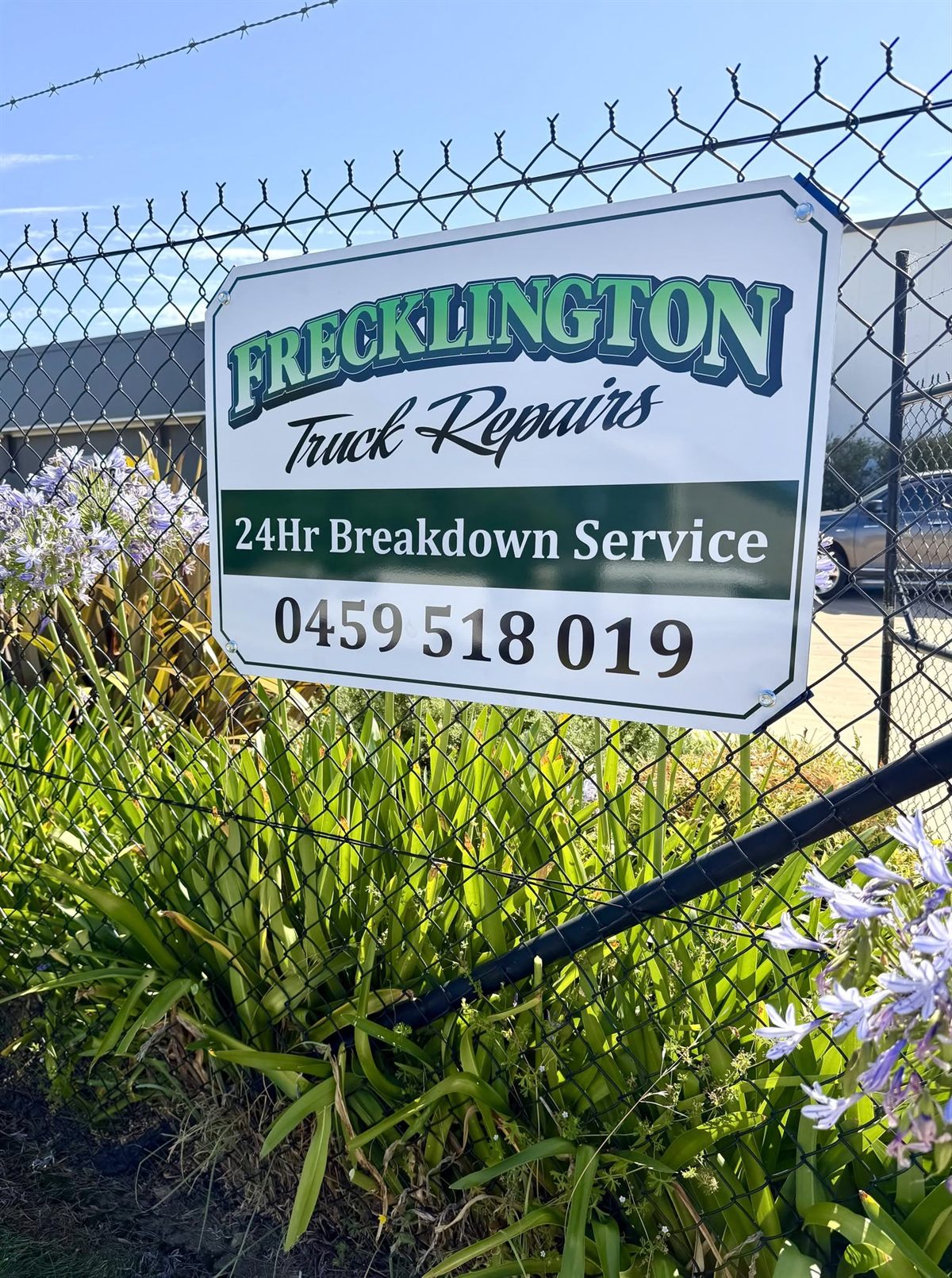 Frecklington Truck Repairs signboard on the workshop fence advertising the 24hr breakdown service